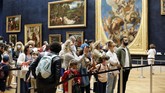 Bertemu lagi dengan Monalisa di Museum Louvre Visitors watch the Leonardo da Vinci's painting Mona Lisa, in Paris, Monday, July 6, 2020. The home of the world's most famous portrait, the Louvre Museum in Paris, reopened Monday after a four-month coronavirus lockdown. (AP Photo/ Thibault Camus)