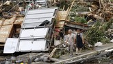 Pencarian Korban Banjir di Jepang A couple walks near debris from a heavy rain in Kumamura, Kumamoto prefecture, southern Japan Monday, July 6, 2020. Rescue operations continued and rain threatened wider areas of the main island of Kyushu. (Kyodo News via AP)