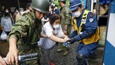 pencarian Korban Banjir di Jepang A woman is helped to get into a police vehicle to move from a shelter to another shelter in Kumamura, Kumamoto prefecture, southern Japan Monday, July 6, 2020. Rescue operations continued and rain threatened wider areas of the main island of Kyushu. (Kota Endo/Kyodo News via AP)