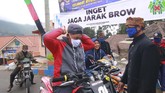 Tradisi Yadnya Kasada Suku Tengger di Gunung Bromo Petugas memberikan masker kepada pengunjung yang tidak memakai masker pada ritual adat Yadnya Kasada di Tengger, Gunung Bromo, Probolinggo, Jawa Timur, Senin (6/7/2020). Ritual yadnya kasada yang digelar dimasa pandemi COVID-19 itu, diberlakukan pembatasan untuk umat Hindu yang ada di Tengger saja. ANTARA FOTO/Budi Candra Setya/hp.