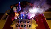 Warga Argentina saat karantina Marcela Alvarez holds her birthday party in her home's balcony, one of many celebrations she's held from her balcony during the lockdown to curb the spread of COVID-19 in Buenos Aires, Friday, June 26, 2020. Alvarez's neighbors caught on to her idea and started celebrating special dates from their own balconies, like Father's Day, birthdays, even marking the deaths of passed relatives. Marcela says she now considers her neighbors to be like family. (AP Photo/Natacha Pisarenko)