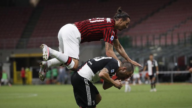 AC Milan's Zlatan Ibrahimovic, jumps for the ball with Juventus' Leonardo Bonucci, below, during the Serie A soccer match between AC Milan and Juventus at the San Siro stadium, in Milan, Italy, Tuesday, July 7, 2020. (AP Photo/Antonio Calanni)