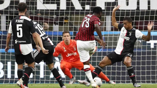AC Milan's Franck Kessie, center, scores against Juventus during the Serie A soccer match between AC Milan and Juventus at the San Siro stadium, in Milan, Italy, Tuesday, July 7, 2020. (AP Photo/Antonio Calanni)