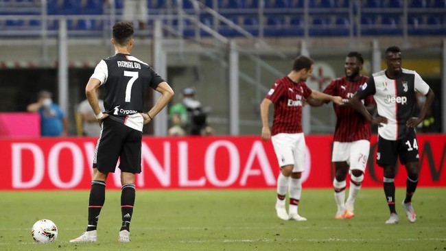 Juventus' Cristiano Ronaldo, left, reacts after AC Milan's Ante Rebic scores against Juventus during the Serie A soccer match between AC Milan and Juventus at the San Siro stadium, in Milan, Italy, Tuesday, July 7, 2020. (AP Photo/Antonio Calanni)