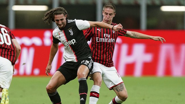 AC Milan's Andrea Conti, right, and Juventus' Adrien Rabiot vie for the ball during the Serie A soccer match between AC Milan and Juventus at the Milan San Siro Stadium, Italy, Tuesday, July 7, 2020. (Spada/LaPresse via AP)