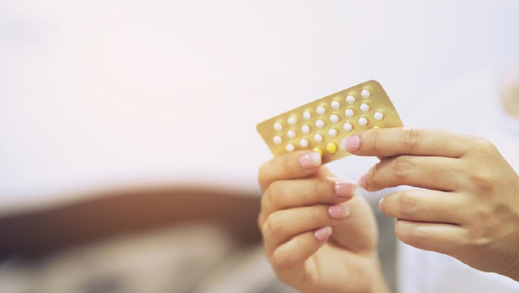 Woman hands opening birth control pills in hand. Eating Contraceptive Pill.