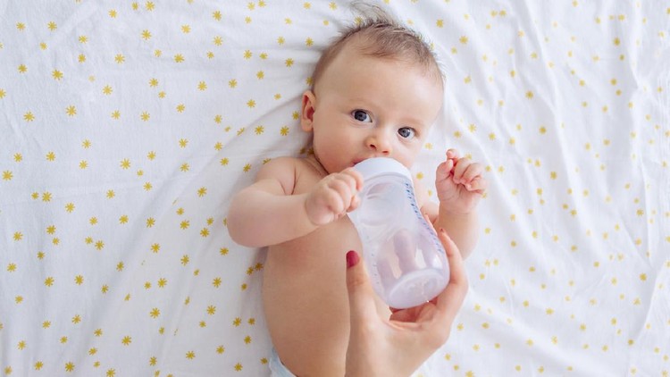 Mother give baby water from baby bottle, baby likes it