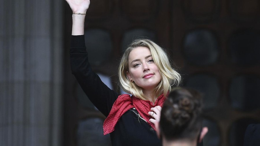 Actress Amber Heard, center, arrives at the High Court in London, Tuesday, July 7, 2020. Johnny Depp has a starring role in a real-life courtroom drama in London, where he is suing a tabloid newspaper for libel over an article that branded him a 