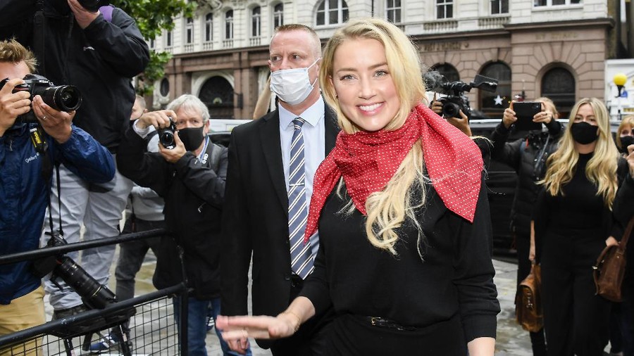 Actress Amber Heard, center, arrives at the High Court in London, Tuesday, July 7, 2020. Johnny Depp has a starring role in a real-life courtroom drama in London, where he is suing a tabloid newspaper for libel over an article that branded him a 