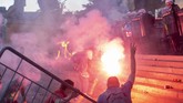 demo rusuh serbia Protesters clash with riot police on the steps of the Serbian parliament in Belgrade, Serbia, Wednesday, July 8, 2020. Police have fired tear gas at protesters in Serbia's capital during the second day of demonstrations against the president's handling of the country's coronavirus outbreak. President Aleksandar Vucic backtracked on his plans to reinstate a coronavirus lockdown in Belgrade this week, but it didn't stop people from firing flares and throwing stones while trying to storm the downtown parliament building. (AP Photo/Marko Drobnjakovic)