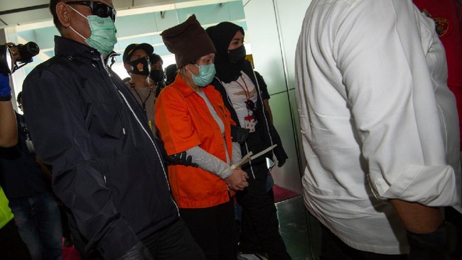 Buronan pelaku pembobolan Bank BNI Maria Pauline Lumowa (kedua kiri) berjalan dengan kawalan polisi usai tiba di Bandara Internasional Soekarno-Hatta, Tangerang, Banten, Kamis (9/7/2020). Tersangka pelaku pembobolan kas Bank BNI cabang Kebayoran Baru lewat Letter of Credit (L/C) fiktif sebesar Rp1,7 triliun diekstradisi dari Serbia setelah menjadi buronan sejak 2003. ANTARA FOTO/Aditya Pradana Putra/nz.
  *** Local Caption ***