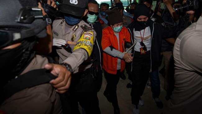Buronan pelaku pembobolan Bank BNI Maria Pauline Lumowa (tengah) berjalan dengan kawalan polisi usai tiba di Bandara Internasional Soekarno-Hatta, Tangerang, Banten, Kamis (9/7/2020). Tersangka pelaku pembobolan kas Bank BNI cabang Kebayoran Baru lewat Letter of Credit (L/C) fiktif sebesar Rp1,7 triliun diekstradisi dari Serbia setelah menjadi buronan sejak 2003. ANTARA FOTO/Aditya Pradana Putra/nz.
  *** Local Caption ***