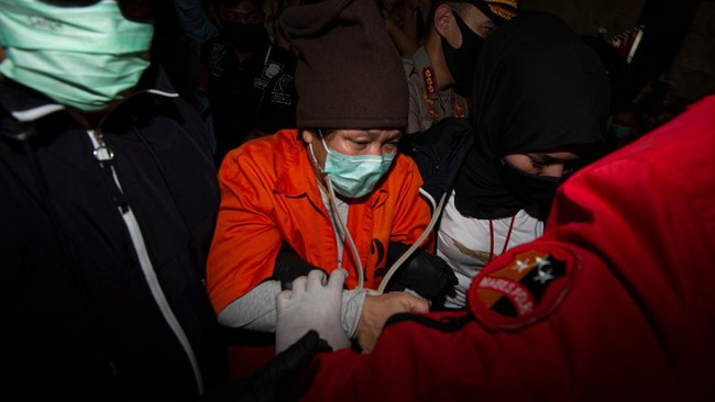 Buronan pelaku pembobolan Bank BNI Maria Pauline Lumowa (tengah) berjalan dengan kawalan polisi usai tiba di Bandara Internasional Soekarno-Hatta, Tangerang, Banten, Kamis (9/7/2020). Tersangka pelaku pembobolan kas Bank BNI cabang Kebayoran Baru lewat Letter of Credit (L/C) fiktif sebesar Rp1,7 triliun diekstradisi dari Serbia setelah menjadi buronan sejak 2003. ANTARA FOTO/Aditya Pradana Putra/nz.
  *** Local Caption ***
