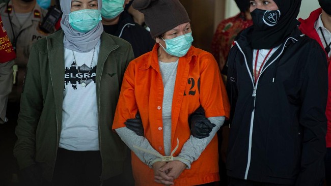 Buronan pelaku pembobolan Bank BNI Maria Pauline Lumowa (tengah) berjalan dengan kawalan polisi usai tiba di Bandara Internasional Soekarno-Hatta, Tangerang, Banten, Kamis (9/7/2020). Tersangka pelaku pembobolan kas Bank BNI cabang Kebayoran Baru lewat Letter of Credit (L/C) fiktif sebesar Rp1,7 triliun diekstradisi dari Serbia setelah menjadi buronan sejak 2003. ANTARA FOTO/Aditya Pradana Putra/nz.
  *** Local Caption ***
