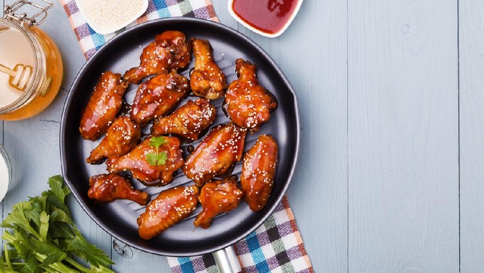Baked chicken wings in honey sauce sprinkled with sesame seeds.