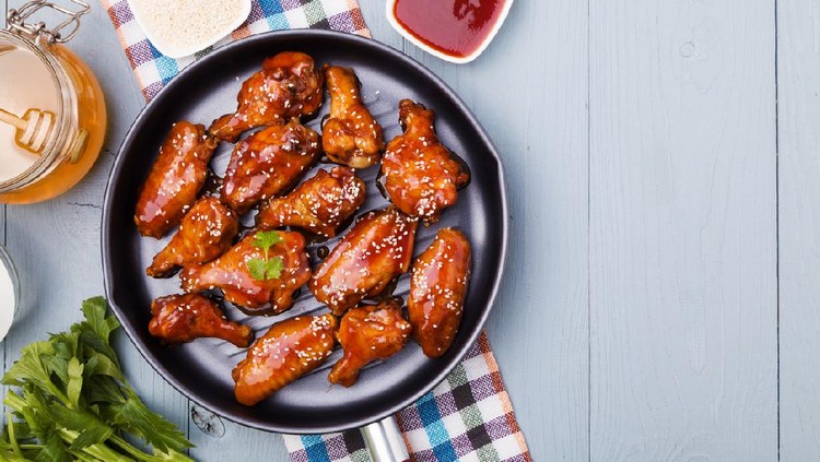 Baked chicken wings in honey sauce sprinkled with sesame seeds.
