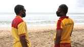 PANTAI KUTA BALI DIBUKA KEMBALI Rescue team wearing face masks stand guard at Kuta beach, Bali, Indonesia on Thursday, July 9, 2020. Indonesia's resort island of Bali reopened after a three-month virus lockdown Thursday, allowing local people and stranded foreign tourists to resume public activities before foreign arrivals resume in September.(AP Photo/Firdia Lisnawati)
