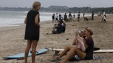 PANTAI KUTA BALI DIBUKA KEMBALI Tourists are seen at Kuta beach, Bali, Indonesia on Thursday, July 9, 2020. Indonesia's resort island of Bali reopened after a three-month virus lockdown Thursday, allowing local people and stranded foreign tourists to resume public activities before foreign arrivals resume in September. (AP Photo/Firdia Lisnawati)