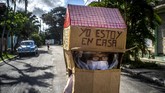 Seorang Nenek di Kuba Tangkal Corona Dengan Kardus Feridia Rojas, a retired nurse, wears a cardboard box as a protective measure against the spread of the new coronavirus, in Havana, Cuba, Wednesday, July 8, 2020. The 82-year-old pensioner shuffles through the streets of Havana on shopping excursions wearing the cardboard box with a handwritten message that reads in Spanish,