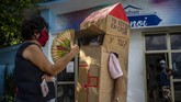 Seorang Nenek di Kuba Tangkal Corona Dengan Kardus A woman chats with retired nurse Feridia Rojas who wears a cardboard box as a protective measure against the spread of the new coronavirus, in Havana, Cuba, Wednesday, July 8, 2020. The 82-year-old pensioner shuffles through the streets of Havana on shopping excursions wearing the cardboard box, with a handwritten message that reads in Spanish,