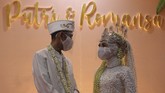 SIMULASI RESEPSI PERNIKAHAN NORMAL BARU Pasangan pengantin Kumala dan Putri berbincang dengan mengenakan masker dan pelindung wajah saat simulasi resepsi pernikahan di masa normal baru di Hotel Royal Singosari Cendana, Surabaya, Jawa Timur, Senin (6/7/2020). Kegiatan simulasi resepsi pernikahan tersebut bertujuan untuk mengedukasi masyarakat tentang pentingnya penerapan protokol kesehatan dalam acara pernikahan guna mencegah penyebaran dan penularan COVID-19 di masa normal baru. ANTARA FOTO/Moch Asim/wsj.