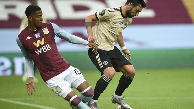 Manchester United's Bruno Fernandes, right, is tackled by Aston Villa's Ezri Konsa during the English Premier League soccer match between Aston Villa and Manchester United at Villa Park in Birmingham, England, Thursday, July 9, 2020. (AP Photo/Oli Scarff,Pool)