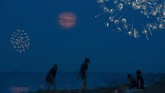 Nyalang Edisi 11 Juli 2020 Revelers look out over Wisconsin Point as fireworks were shot off and a waxing gibbous moon rose over the horizon, seen from Superior, Wis., Saturday, July 4, 2020. (Alex Kormann/Star Tribune via AP)