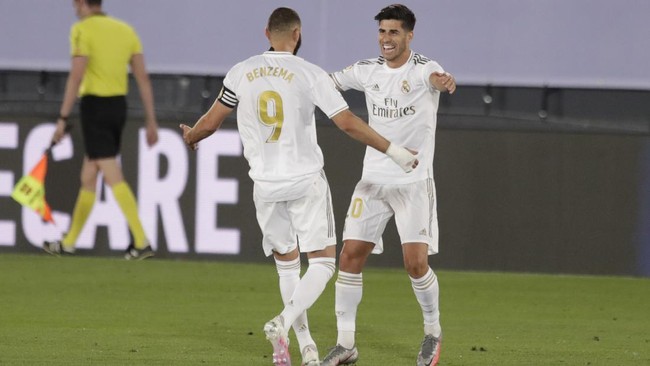 Real Madrid's Marco Asensio, right, celebrates hit his teammate Karim Benzema after scoring during the Spanish La Liga soccer match between Real Madrid and Deportivo Alaves at the Alfredo di Stefano stadium in Madrid, Spain, Friday, July 10, 2020. (AP Photo/Bernat Armangue)