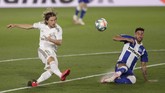 Spain Soccer La Liga Real Madrid's Luka Modric, left, shoots the ball as Deportivo Alaves' Victor Camarasa tries to stop him, during the Spanish La Liga soccer match between Real Madrid and Deportivo Alaves at the Alfredo di Stefano stadium in Madrid, Spain, Friday, July 10, 2020. (AP Photo/Bernat Armangue)