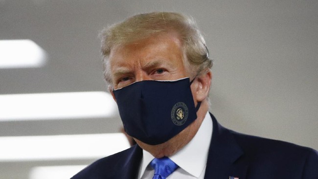 President Donald Trump wears a face mask as he walks down a hallway during a visit to Walter Reed National Military Medical Center in Bethesda, Md., Saturday, July 11, 2020. (AP Photo/Patrick Semansky)