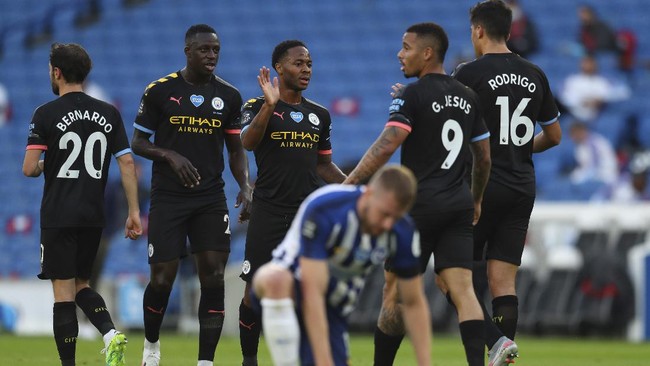 Manchester City's Raheem Sterling, center, celebrates after scoring his side's opening goal during the English Premier League soccer match between Brighton and Manchester City at the Falmer stadium in Brighton, England, Saturday, July 11, 2020. (Julian Finney/Pool via AP)