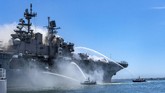 Kapal Perang AS Meledak In a photo provided by the U.S. Navy, Port of San Diego Harbor Police boats fight a fire aboard the USS Bonhomme Richard at Naval Base San Diego on Sunday, July 12, 2020. Twenty-one people suffered minor injuries in an explosion and fire on the ship, military officials said. The blaze was reported shortly before 9 a.m., said Mike Raney, a spokesman for Naval Surface Force, U.S. Pacific Fleet. Seventeen sailors and four civilians were hospitalized with “non-life threatening injuries,” Raney said in a brief statement. (Petty Officer 3rd Class Christina Ross/U.S. Navy via AP)