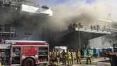 Kapal Perang AS Meledak In a photo provided by the U.S. Navy, sailors and Federal Fire San Diego firefighters work to extinguish a fire aboard the USS Bonhomme Richard on Sunday, July 12, 2020, at Naval Base San Diego. Twenty-one people suffered minor injuries in an explosion and fire Sunday on board a ship, military officials said. The blaze was reported shortly before 9 a.m., said Mike Raney, a spokesman for Naval Surface Force, U.S. Pacific Fleet. Seventeen sailors and four civilians were hospitalized with “non-life threatening injuries,” Raney said in a brief statement. (Petty Officer 1st Class Jason Ko/U.S. Navy via AP)