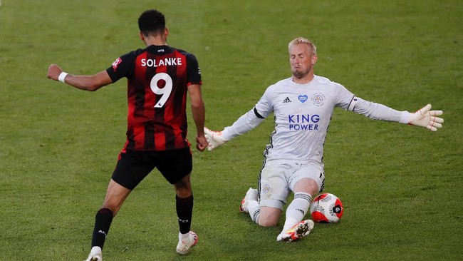 Bournemouth's Dominic Solanke, left, kicks the ball past Leicester's goalkeeper Kasper Schmeichel to score his team's fourth goal during the English Premier League soccer match between Bournemouth and Leicester City at Vitality Stadium in Bournemouth, England, Sunday, July 12, 2020.(AP Photo/Andy Couldridge,Pool)