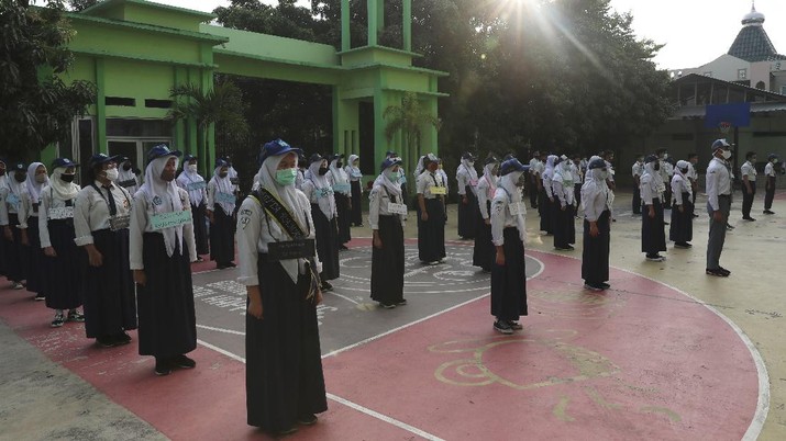 Siswa menggunakan masker dihari pertama masuk sekolah negeri di Bekasi. AP/Achmad Ibrahim