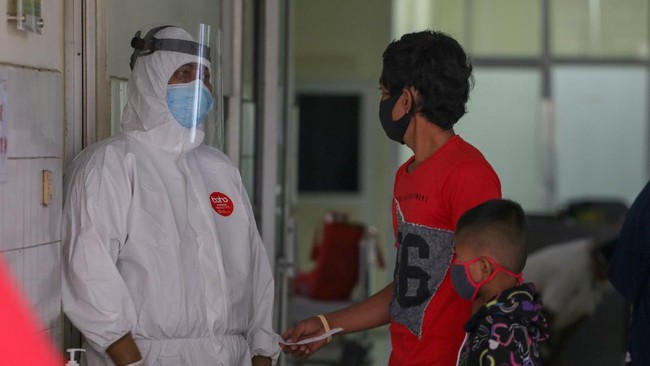Seorang tenaga kesehatan dengan pakaian pelindung diri lengkap berbincang dengan keluarga pasien di ruangan pemeriksaan COVID-19 di rumah sakit rujukan COVID-19 RSUD Kabupaten Tangerang, Banten, Senin (13/7/2020). Kementerian Kesehatan menyebutkan per 8 Juli 2020, dari total anggaran insentif tenaga kesehatan COVID-19 sebesar Rp1,9 triliun telah menyalurkannya sebesar Rp284,5 miliar kepada 94.057 tenaga kesehatan baik yang ada di fasilitas pelayanan kesehatan dan institusi kesehatan pusat. ANTARA FOTO/Fauzan/wsj.
