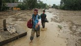 BANJIR BANDANG LUWU UTARA Dua warga melintasi lumpur akibat banjir bandang di Desa Radda, Kabupaten Luwu Utara, Sulawesi Selatan, Selasa (14/7/2020). Petugas BPBD Sulawesi Selatan masih menginventarisasi kerugian akibat banjir bandang pada Senin, 13 Juli 2020 yang mengakibatkan puluhan rumah terbawa arus, dua orang meninggal dan tujuh orang hilang. ANTARA FOTO/Indra/wpa/foc.