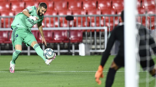 Real Madrid's Karim Benzema kicks the ball during the Spanish La Liga soccer match between Granada and Real Madrid at the Los Carmenes stadium in Granada, Spain, Monday, July 13, 2020. (AP Photo/Jose Breton)