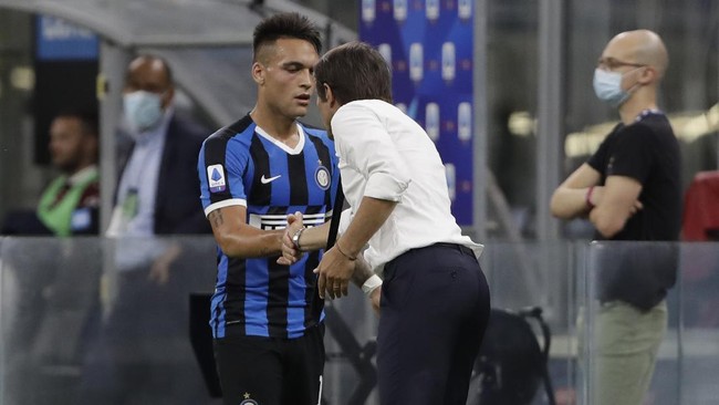 Inter Milan's Lautaro Martinez, left, shake hands with Inter Milan's head coach Antonio Conte after scoring his side's third goal during a Serie A soccer match between Inter Milan and Torino, at the San Siro stadium in Milan, Italy, Monday, July 13, 2020. (AP Photo/Luca Bruno