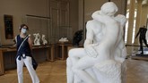 Museum Rodin Dibuka Kembali A visitor watches Le Baiser (The Kiss) by French sculptor Auguste Rodin in Paris Tuesday, July 7, 2020. The Musee Rodin is reopening this morning albeit with a worrying loss of visitors and income caused by the four-months closure. Museum director, Catherine Chevillot, estimates the loss incurred by the crisis to be around 4.4 million euros (4.9 US dollars). and alleviated by the 1.4 million euro sales of bronze editions of Rodin statues. The museum doesn't sell Rodin statue originals but can sell 12 bronze replica editions of each of them, as it has been for 100 years. (AP Photo/Christophe Ena)