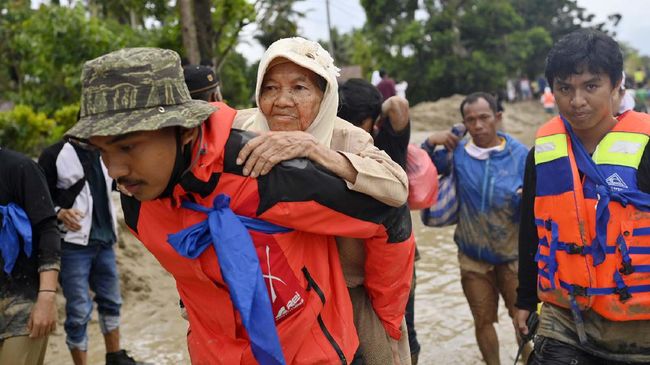 Tim SAR menggendong seorang korban banjir bandang saat dievakuasi di Desa Radda, Kabupaten Luwu Utara, Sulawesi Selatan, Selasa (14/7/2020). Akibat banjir bandang tersebut mengakibatkan 10 orang meninggal dunia dan ratusan rumah tertimbun lumpur. ANTARA FOTO/Hariandi Hafid/yu/hp.