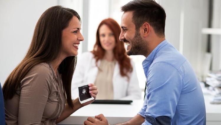 Doctor during consultation held in his hand and shows patient anatomical model of male sperm. Counseling of men and couples about male infertility, sperm pathology, impossibility to get pregnant