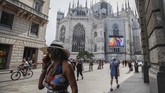Milan Digital Fashion Week Pedestrians pass by a screen on the Duomo cathedral, showing a Moschino model during the Milan Digital Fashion Week, in Milan, Italy, Tuesday, July 14, 2020. Forty fashion houses are presenting previews of menswear looks for next spring and summer and pre-collections for women in digital formats, due to concerns generated by the COVID-19. (AP Photo/Luca Bruno)