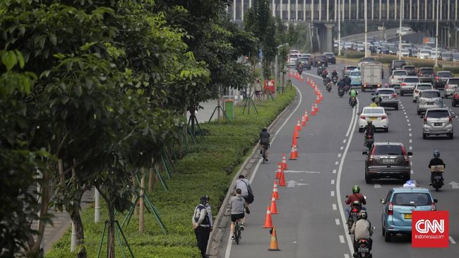 Warga menggunakan sepeda di jalur khusus sepeda di kawasan Jalan Sudirman, Jakarta, Rabu, 15 Juli 2020. Pemprov DKI akan meniadakan jalur sepeda di Jalan Jenderal Sudirman hingga Jalan MH Thamrin setiap hari Minggu. CNN Indonesia/Adhi Wicaksono