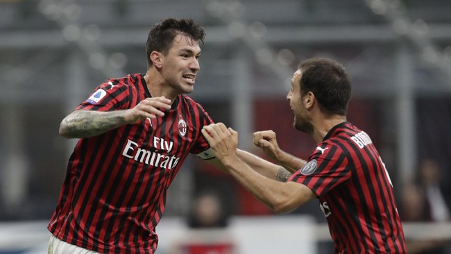 AC Milan's Alessio Romagnoli, celebrates his goal with his teammate Giacomo Bonaventura, right, during a Serie A soccer match between AC Milan and Parma, at the San Siro stadium in Milan, Italy, Wednesday, July 15, 2020. (AP Photo/Luca Bruno)
