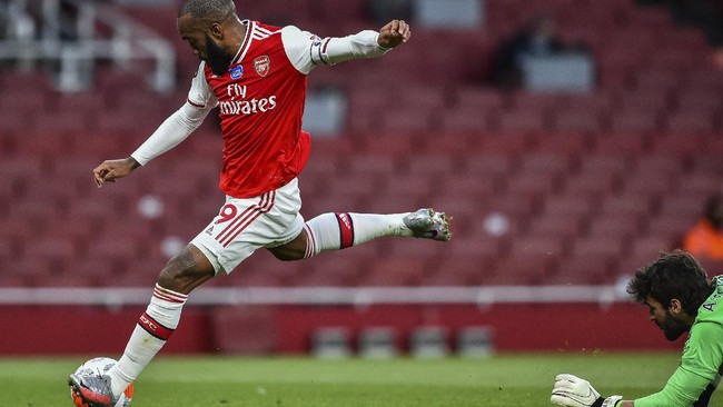 Arsenal's Alexandre Lacazette scores his team first goal during the English Premier League soccer match between Arsenal and Liverpool at the Emirates Stadium in London, England, Wednesday, July 15, 2020. (Glyn Kirk/Pool via AP)