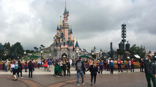 Disneyland Paris Visitors and staff wearing protective face masks, walk down the Main Street of Disneyland Paris in Marne-la-Vallee, near Paris, on July 15, 2020, as Disneyland Paris begins phased reopening after months-closure aimed at stemming the spread of the novel coronavirus (COVID-19). (Photo by Aurelia MOUSSLY / AFP)