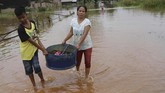 Korban Banjir Konawe Warga mengangkat barang dari rumahnya yang terendam banjir di Desa Laloika, Kecamatan Pondidaha, Konawe, Sulawesi Tenggara, Senin (13/7/2020). Banjir yang melanda Desa Laloika dan Desa Wonuamonapa sejak pekan lalu tersebut diakibatkan meluapnya Sungai Konaweha sehingga 106 rumah warga terendam banjir dan 354 warga mengungsi. ANTARA FOTO/Jojon/wsj.