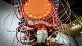 Nyalang Edisi 18 Juli 2020 A woman wearing a face mask has her hair curled by a special equipment at a beauty salon in Bangkok on July 12, 2020. (Photo by Mladen ANTONOV / AFP)