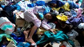 Ribuan Jiwa Mengungsi Akibat Banjir Bandang Masamba Anak-anak korban banjir bandang berada di tumpukan pakaian layak pakai saat mengungsi di kawasan kantor Bupati Luwu Utara, Sulawesi Selatan, Kamis (16/7/2020). Sebanyak 15.994 jiwa mengungsi di sejumlah posko pengungsian karena rumah mereka rusak dan hilang akibat tertimbun lumpur setelah diterjang banjir bandang. ANTARA FOTO/Abriawan Abhe/nz